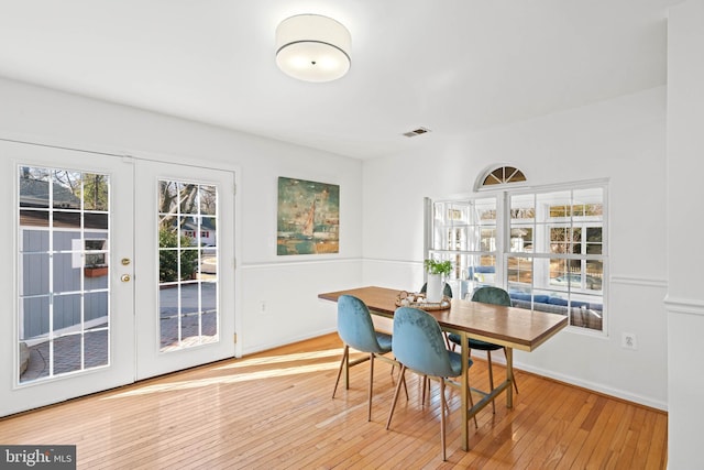 dining room with plenty of natural light, french doors, wood-type flooring, and visible vents