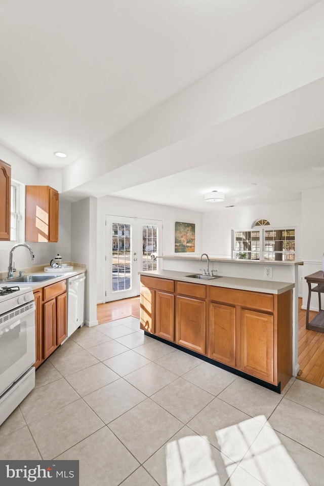 kitchen with light countertops, white appliances, a sink, and french doors