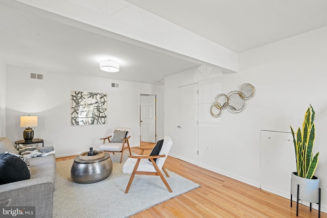 living area featuring light wood-style floors, baseboards, and visible vents