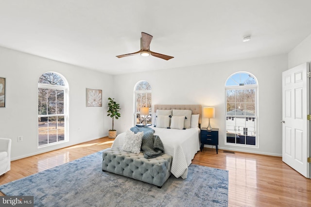 bedroom featuring a ceiling fan, baseboards, and wood finished floors