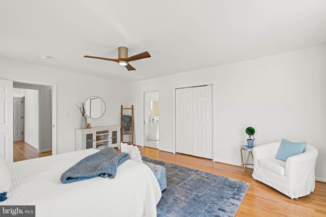 bedroom with connected bathroom, ceiling fan, a closet, and wood finished floors