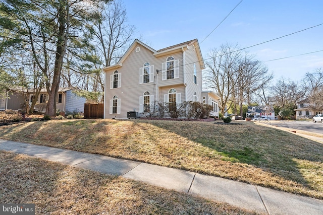 view of front of property with central AC unit and a front lawn