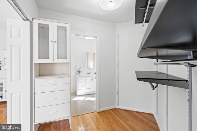 spacious closet featuring a sink and light wood-style flooring