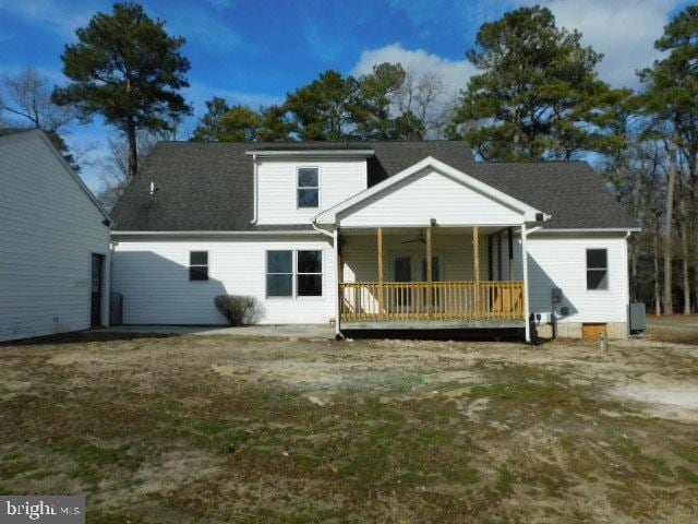 back of house featuring covered porch and a lawn