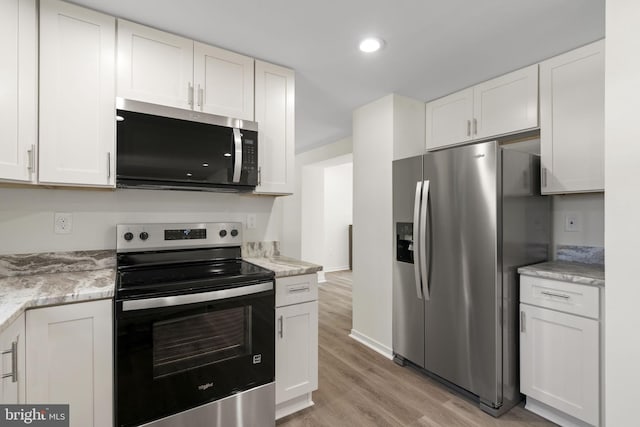 kitchen featuring light stone countertops, white cabinetry, and appliances with stainless steel finishes