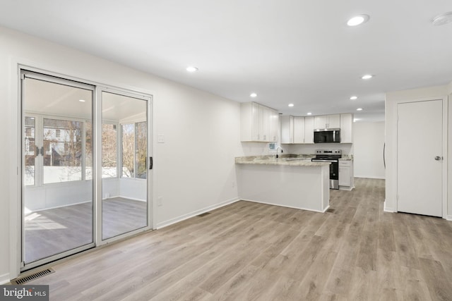 kitchen featuring light wood finished floors, visible vents, white cabinets, appliances with stainless steel finishes, and a peninsula