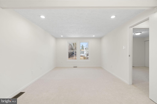 empty room featuring baseboards, visible vents, light colored carpet, a textured ceiling, and recessed lighting