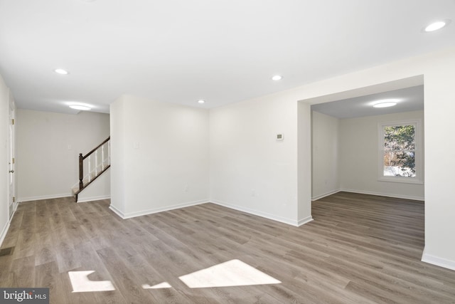 basement with baseboards, stairway, recessed lighting, and light wood-style floors