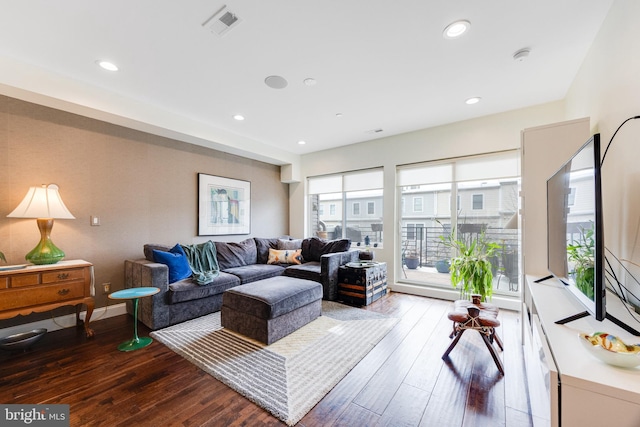 living room with baseboards, wood finished floors, visible vents, and recessed lighting