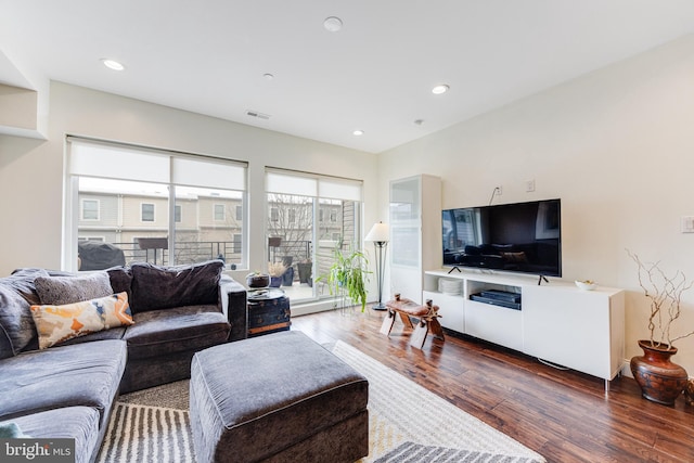 living area featuring baseboard heating, wood finished floors, visible vents, and recessed lighting