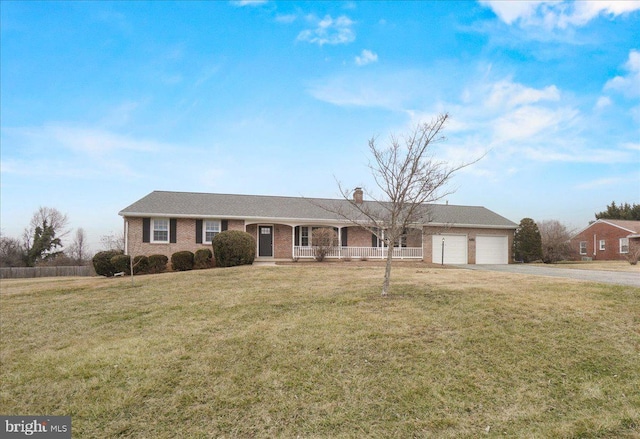 single story home featuring a garage, driveway, brick siding, and a front lawn