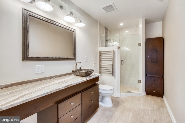 bathroom with toilet, vanity, visible vents, baseboards, and a stall shower