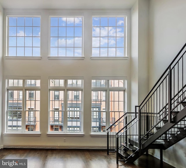 interior space with wood finished floors and a towering ceiling