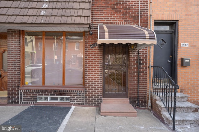 property entrance featuring brick siding