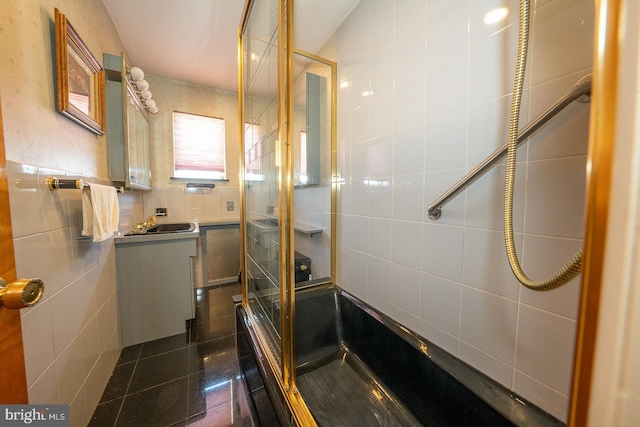 full bathroom with a stall shower, tile walls, and vanity