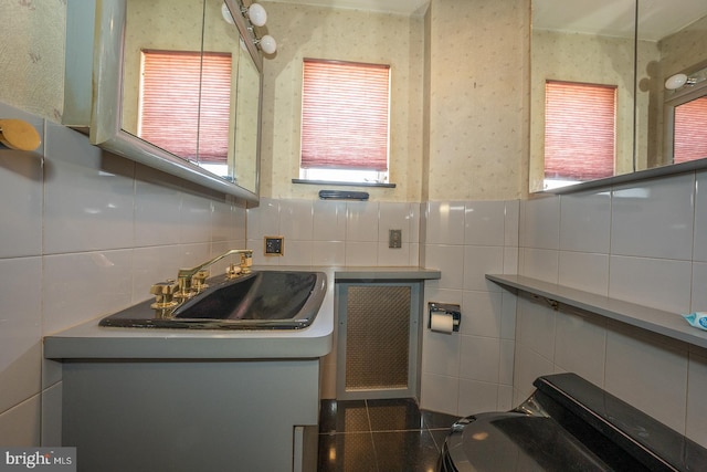 half bath featuring vanity and tile walls