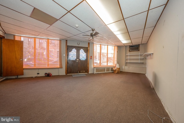 interior space featuring carpet floors, an AC wall unit, a paneled ceiling, and a ceiling fan