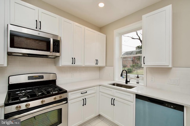 kitchen with white cabinetry, sink, backsplash, and appliances with stainless steel finishes