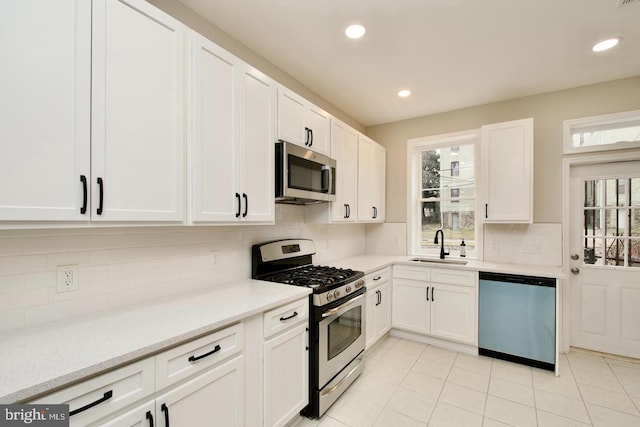 kitchen with white cabinetry, stainless steel appliances, sink, and plenty of natural light