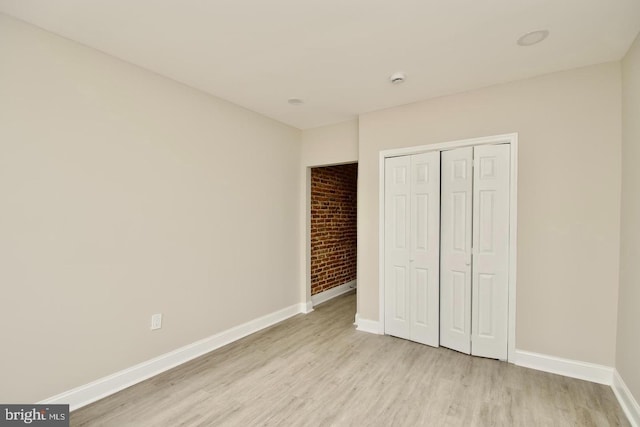 unfurnished bedroom with a closet and light wood-type flooring