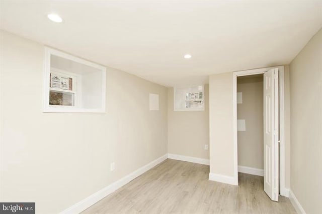 basement with light hardwood / wood-style flooring