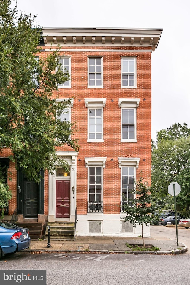 view of front of house featuring entry steps and brick siding