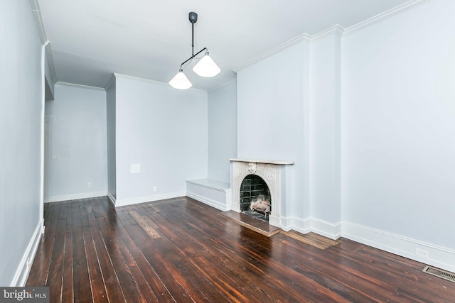 unfurnished living room with crown molding, wood-type flooring, visible vents, a fireplace with raised hearth, and baseboards