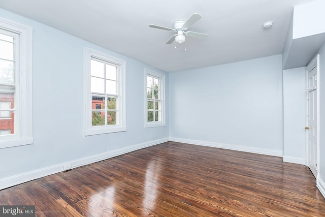 spare room featuring wood finished floors, a ceiling fan, and baseboards