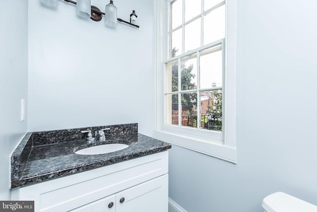 half bathroom with vanity and toilet