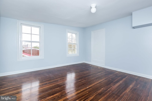 unfurnished room featuring dark wood-style flooring and baseboards