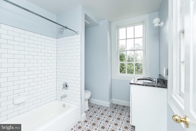 bathroom with bathing tub / shower combination, vanity, toilet, and baseboards