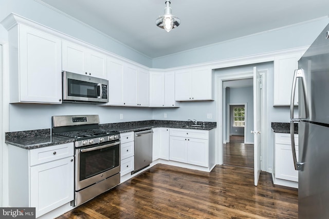 kitchen with stainless steel appliances, white cabinetry, a sink, and dark wood-style floors