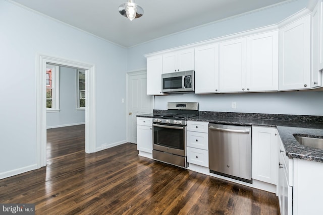 kitchen featuring dark wood-style floors, stainless steel appliances, dark stone counters, and white cabinets