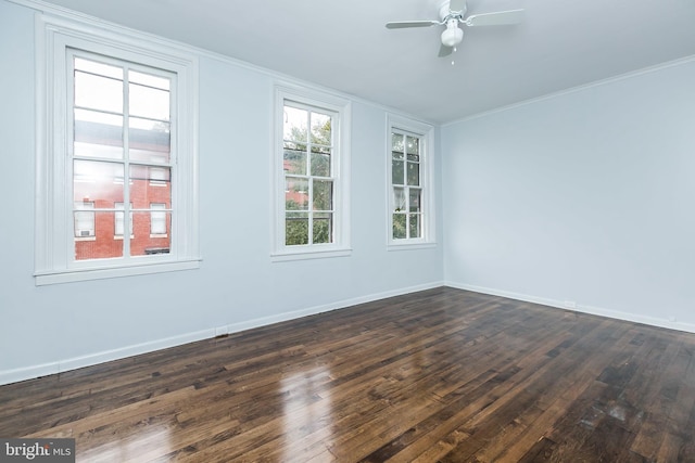 unfurnished room featuring crown molding, dark wood-type flooring, a ceiling fan, and baseboards