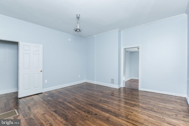 unfurnished room with baseboards, crown molding, visible vents, and wood finished floors