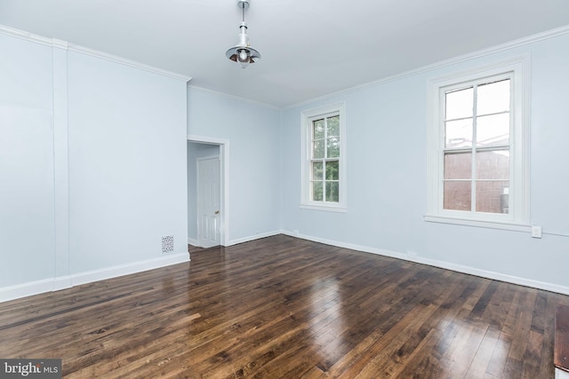 unfurnished room with dark wood-style floors, baseboards, visible vents, and crown molding