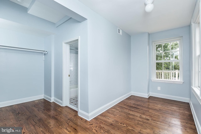 interior space with dark wood-style flooring, visible vents, and baseboards