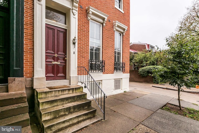 doorway to property featuring brick siding