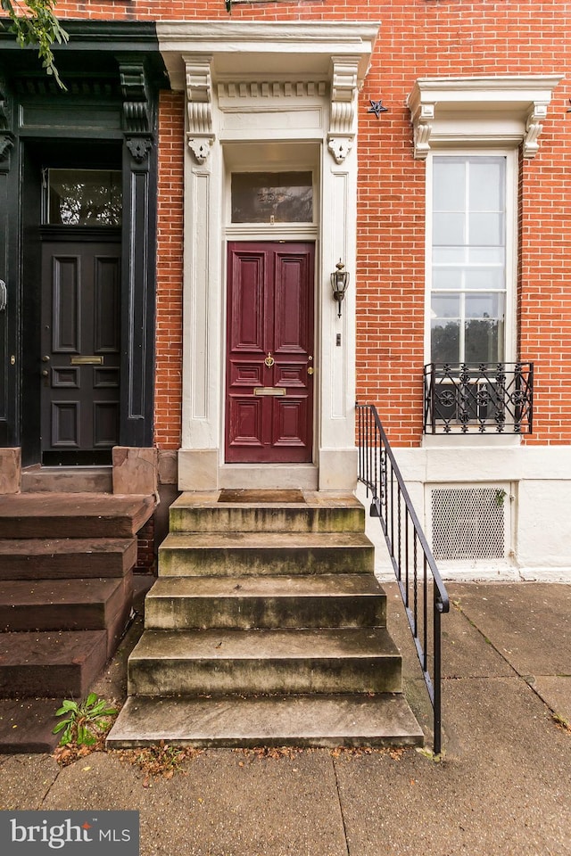 doorway to property featuring brick siding