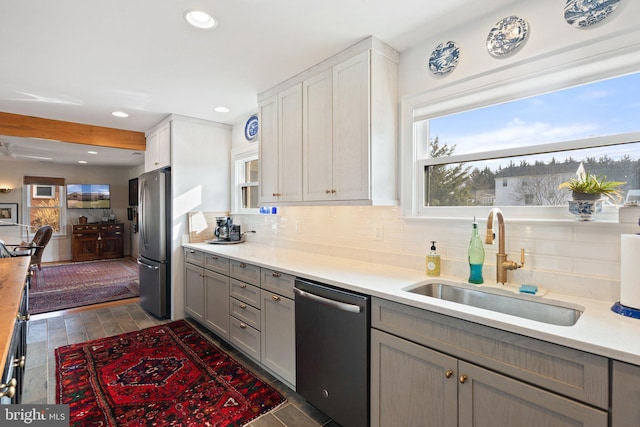 kitchen with gray cabinets, tasteful backsplash, white cabinetry, sink, and stainless steel appliances