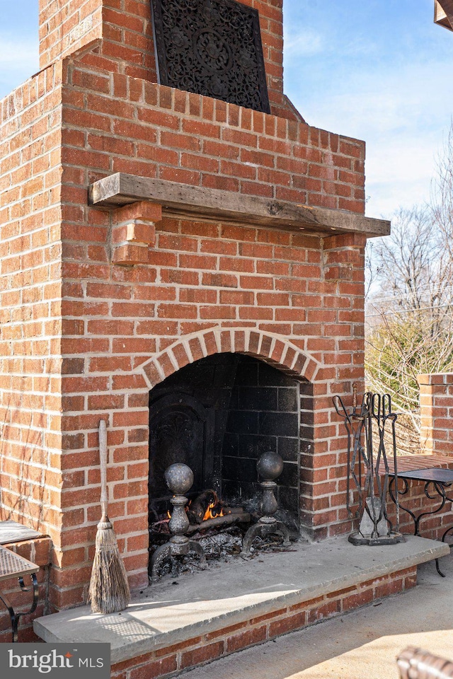 exterior details featuring an outdoor brick fireplace