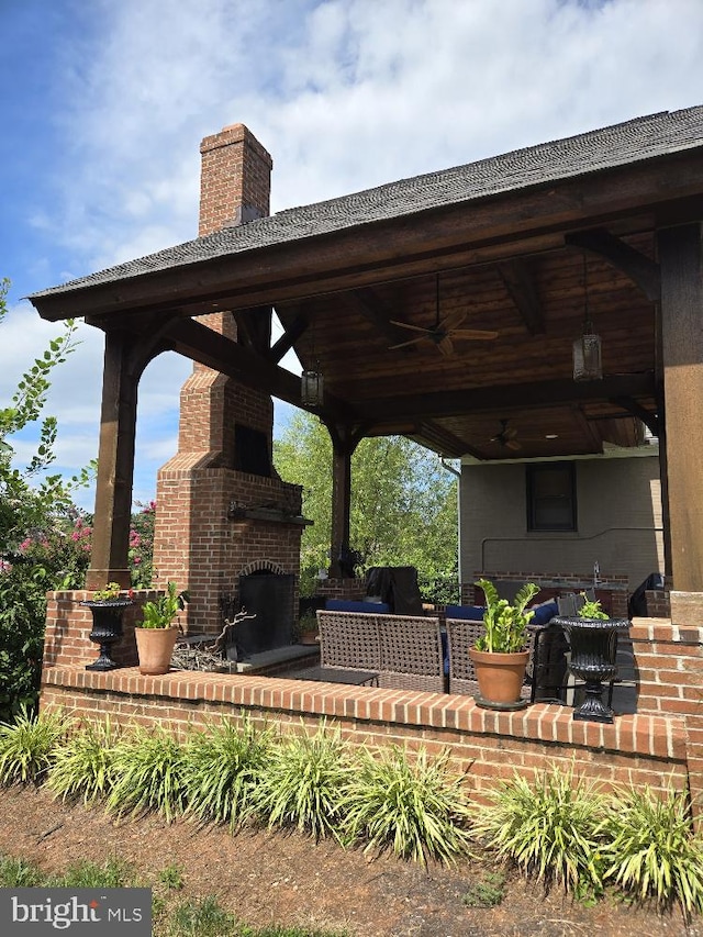 view of patio / terrace with an outdoor brick fireplace, ceiling fan, grilling area, and a gazebo