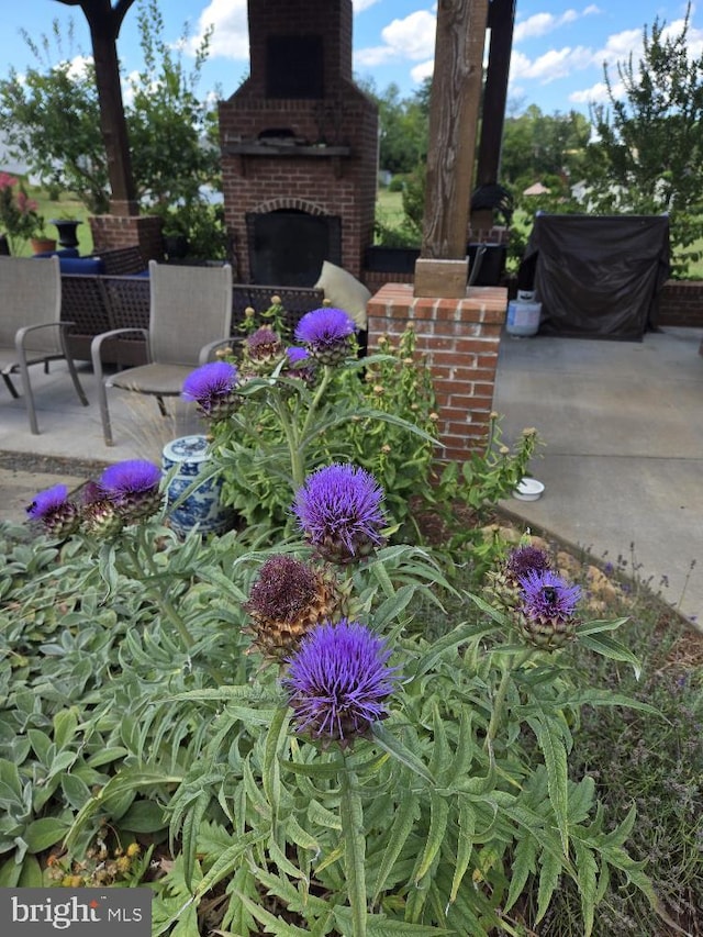 view of patio with an outdoor brick fireplace