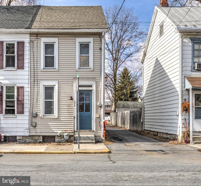 view of property with entry steps, crawl space, fence, and roof with shingles