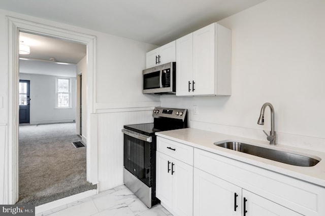 kitchen with marble finish floor, visible vents, appliances with stainless steel finishes, white cabinetry, and a sink