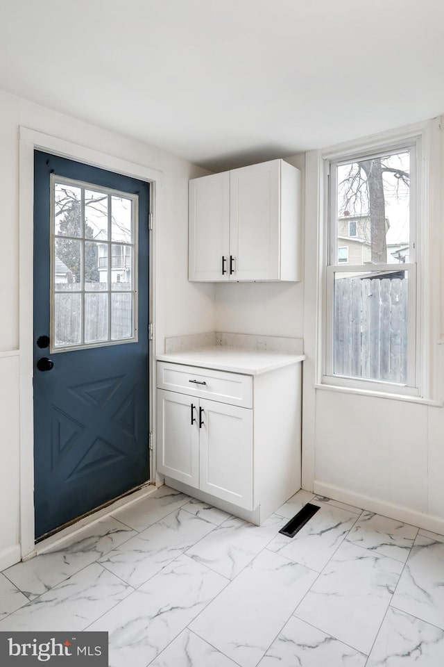 doorway featuring marble finish floor, visible vents, and baseboards