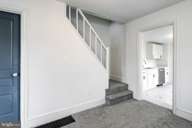 staircase featuring carpet floors, marble finish floor, baseboards, and visible vents