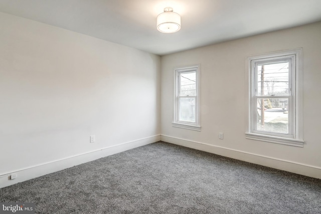 carpeted spare room featuring baseboards