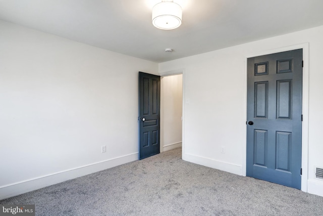 unfurnished bedroom with carpet, visible vents, and baseboards