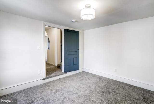 empty room featuring carpet flooring and baseboards